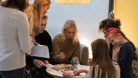 Idolerna sitter vid ett runt bord och skriver autografer