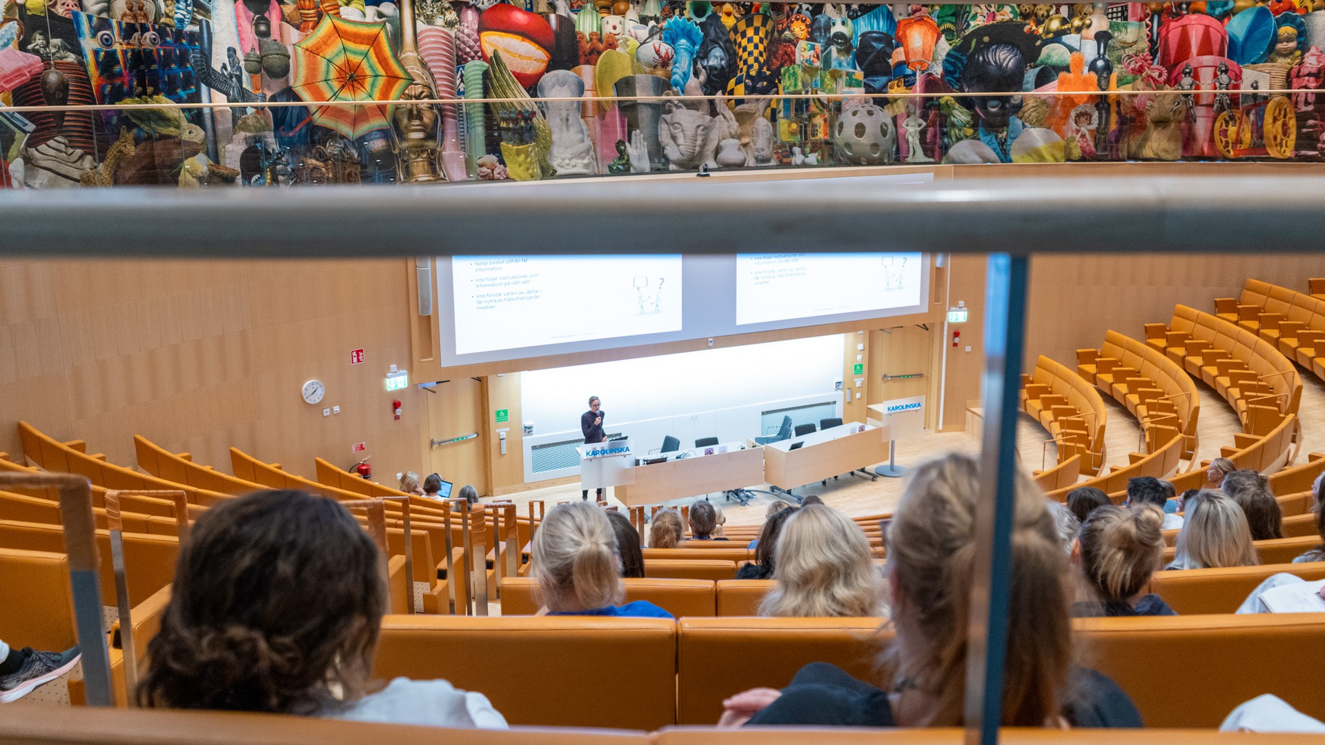 En aula med människor som tittar ner på en föreläsare.