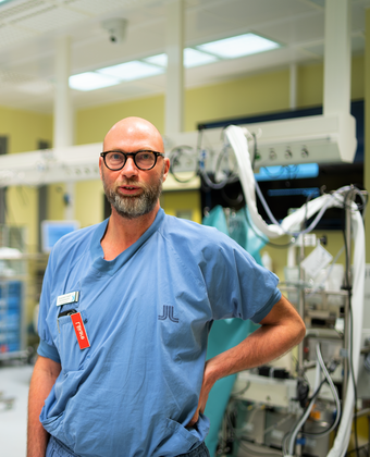 Peter Svenarud i blå arbetskläder inne i operationssalen
