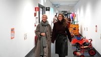 Jennifer och prinsessan Madeleine kommer gående i en korridor.