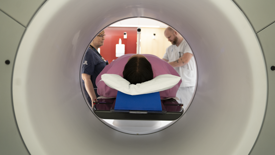 Foton på medarbetare på Strålbehandling som förbereder för behandling med ny maskin