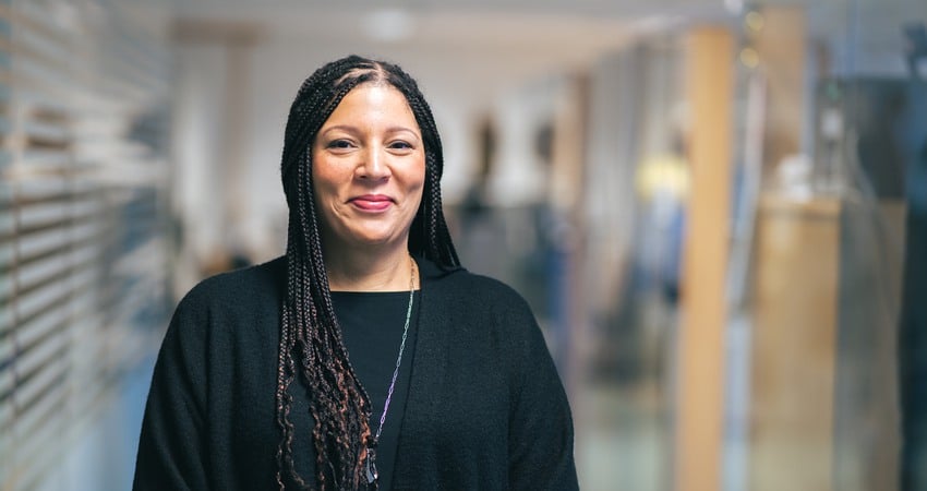 Paulina Essen Olsen står i svart tröja och dreadlocks i håret och ler in i kameran.