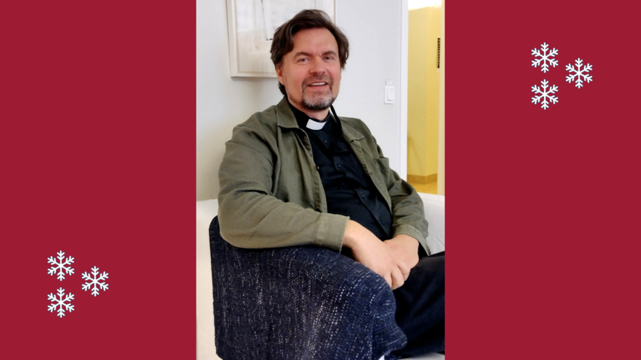 Man med prästkrage sitter i en blå fåtölj.