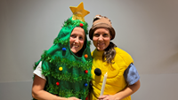 Porträttfoto på två medarbetare ur luciatåget på barnavdelning plan 10. Uppklädda till en julgran och en lussebulle.