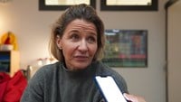 Kristin Kaspersen har grå stickad polotröja och långt mellanblont hår nerstoppat i tröjan.