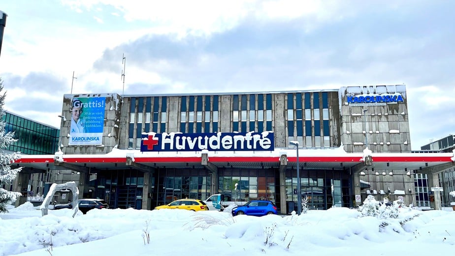 Huvudentrén på utsidan av Karolinska sjukhuset i huddinge en snötäckt dag